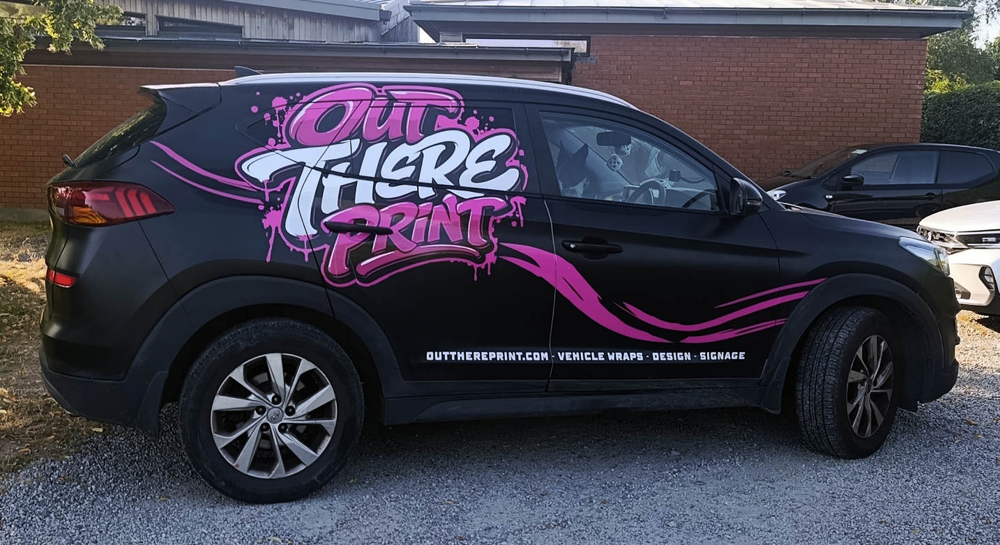 Out There Print Hyundai Tucson with black, pink and white vehicle graphics